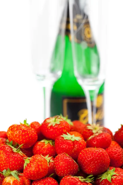 Botella de champán, copa de vino, un plato de fresas aisladas —  Fotos de Stock