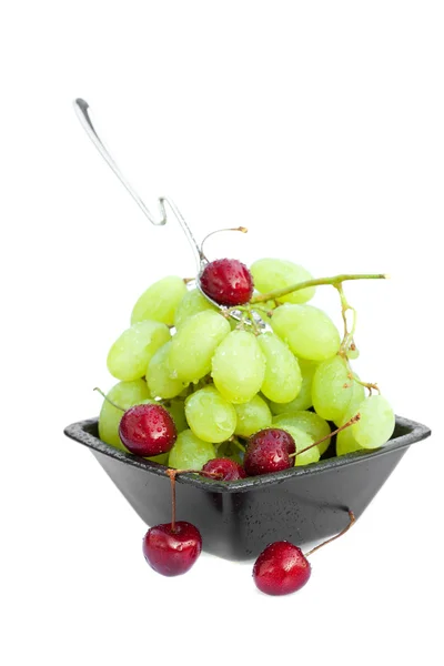 Cup of grapes and cherries isolated on white — Stock Photo, Image