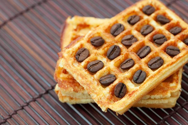 Waffles and coffee beans on a bamboo mat — Stock Photo, Image