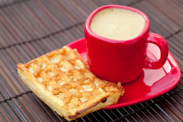 Cup of cappuccino wafers and coffee beans on a bamboo mat — Stock Photo, Image