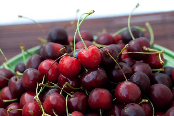 Cherry in plate on a bamboo mat — Stock Photo, Image