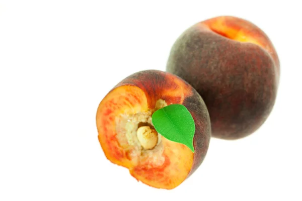 Perziken met groen blad geïsoleerd op wit — Stockfoto
