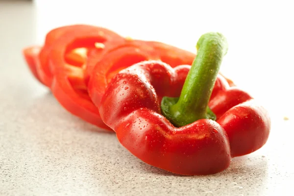 Hackad röd paprika med droppar vatten på bordet — Stockfoto