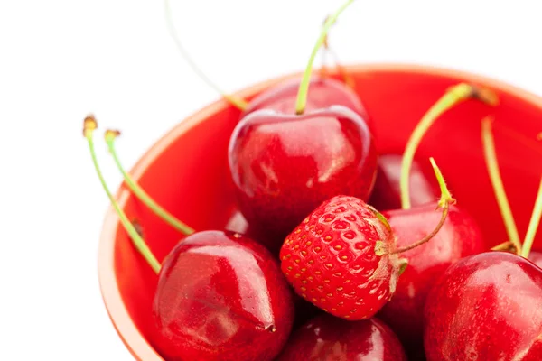 Jordgubbar och körsbär i en skål som isolerad på vit — Stockfoto