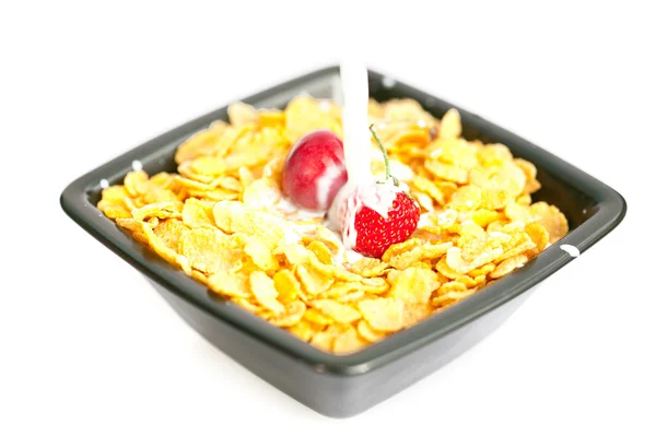 Jordgubbar och körsbär i skålen med cornflakes med mjölk är — Stockfoto