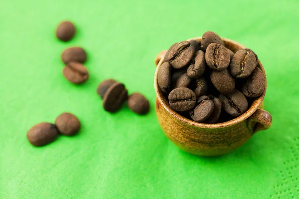 Kleine pot van koffie bonen op de groene zaak — Stockfoto