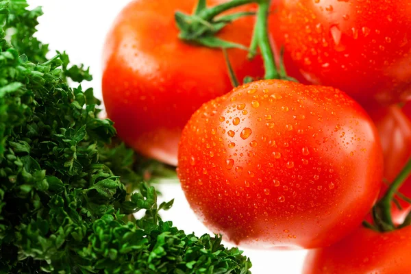 Tomaten und Grünzeug mit Wassertropfen im Glas — Stockfoto