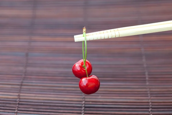 Cherry a hůlky bambusové rohože — Stock fotografie