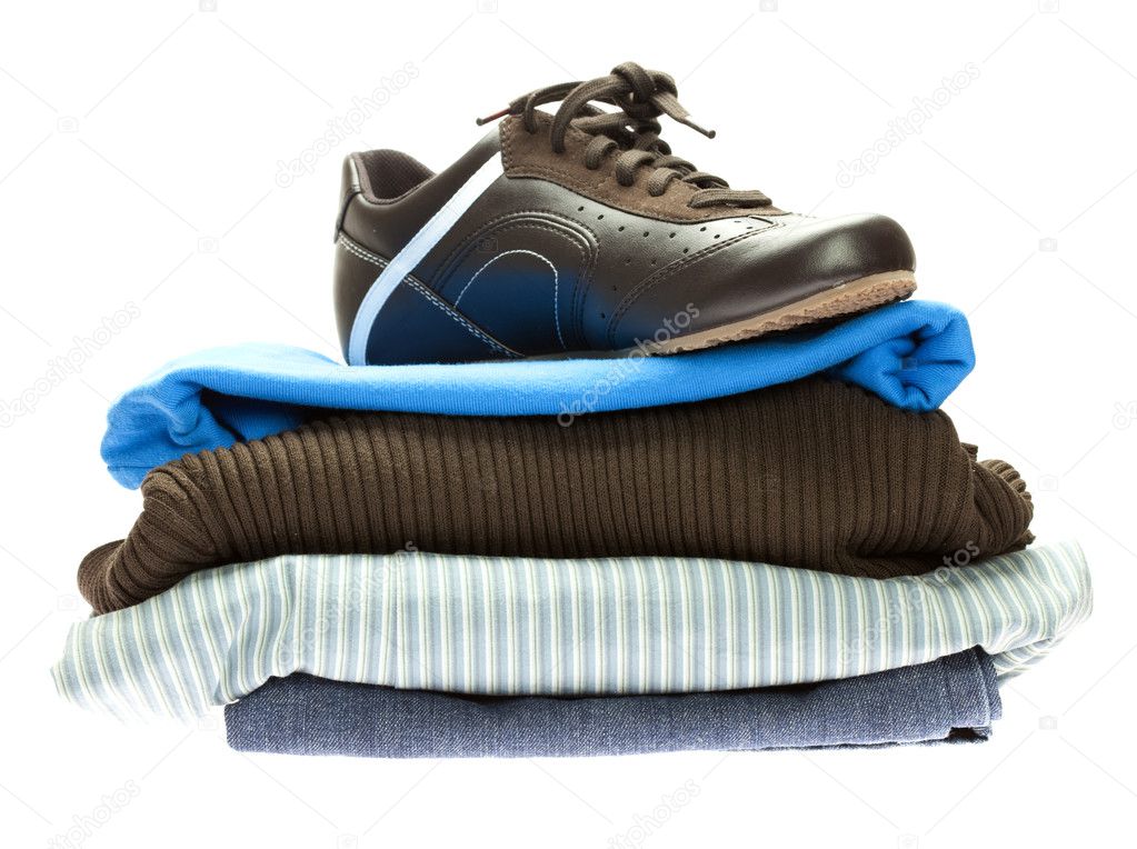 Shoes and a mountain of clothes isolated on white