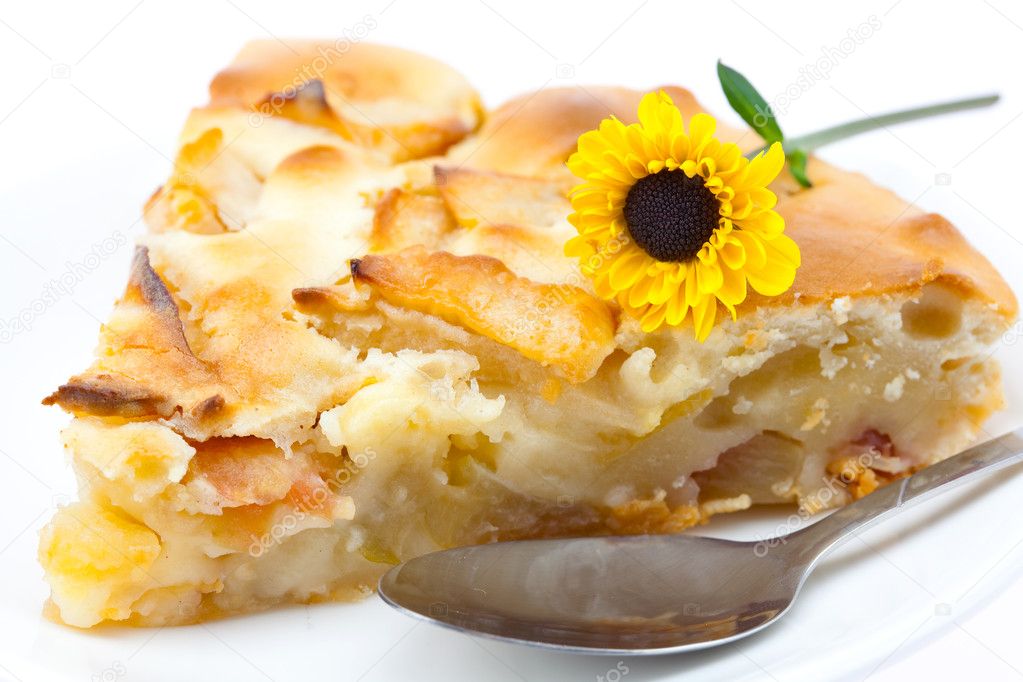 Piece of apple pie and a flower isolated on white