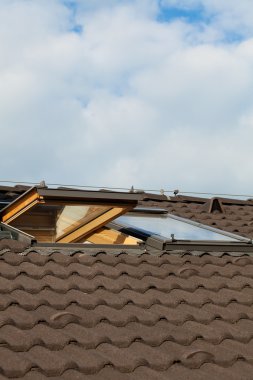 Tiled roof and dormer windows on the skyline clipart