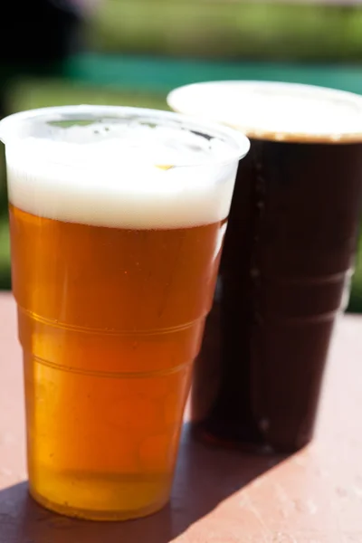 テーブルの上の光と闇のビールのグラス — ストック写真