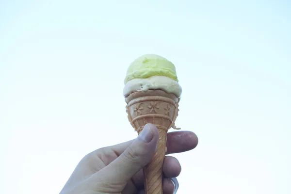 Zmrzlinu v ruce proti obloze — Stock fotografie