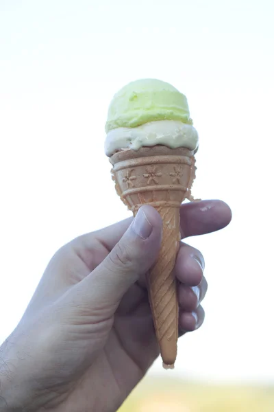 Zmrzlinu v ruce proti obloze — Stock fotografie