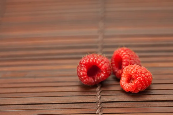 Raspberries on a bamboo mat — Stock Photo, Image