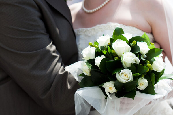 The bride and groom with a bouquet of flowers