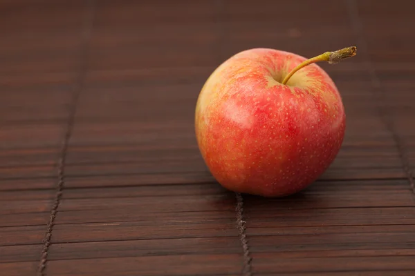 Apfel auf einer Bambusmatte — Stockfoto