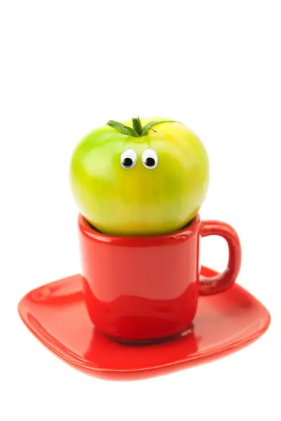 Tomate avec les yeux dans la tasse isolée sur blanc — Photo