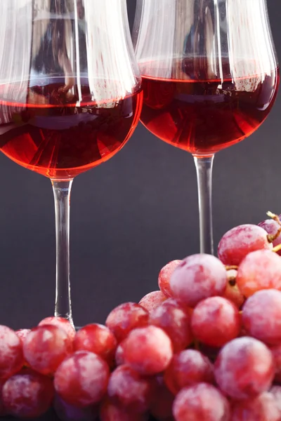 Glass of wine and a bunch of grapes on a black background — Stock Photo, Image