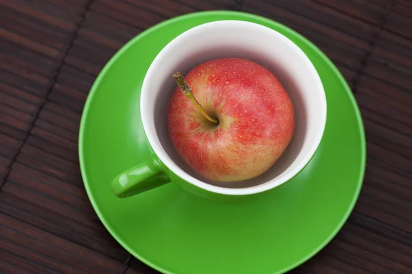 Cup, schotel en appels op een bamboe-mat — Stockfoto