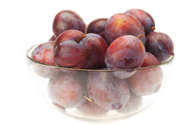 Plums in a glass bowl isolated on white — Stock Photo, Image