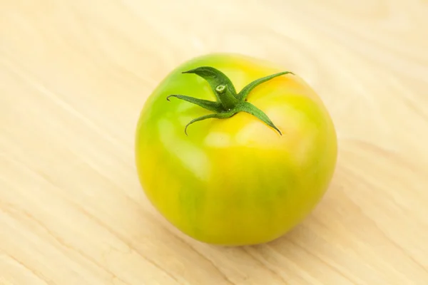 Tomates verdes en una tabla de cortar — Foto de Stock