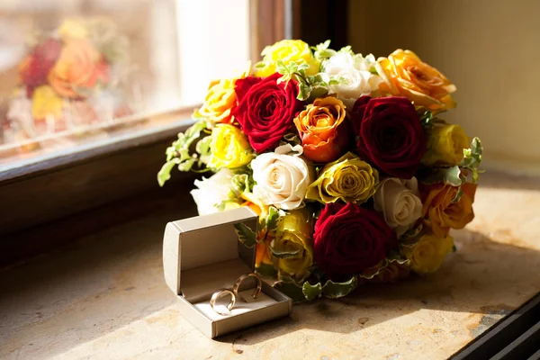 Bridal bouquet and a ring lying on the windowsill — Stock Photo, Image