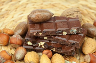 Bar of chocolate and nuts on a wicker mat