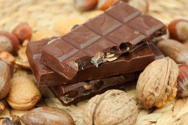 Bar of chocolate and nuts on a wicker mat