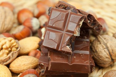 Bar of chocolate and nuts on a wicker mat