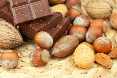 Bar of chocolate and nuts on a wicker mat