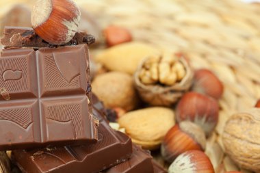 Bar of chocolate and nuts on a wicker mat