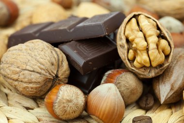 Bar of chocolate and nuts on a wicker mat