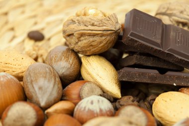 Bar of chocolate and nuts on a wicker mat