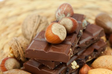 Bar of chocolate and nuts on a wicker mat