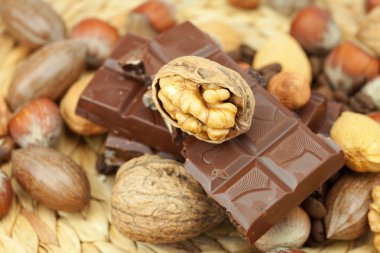 Bar of chocolate and nuts on a wicker mat