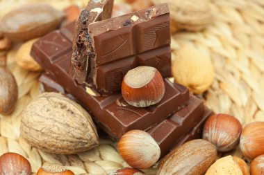 Bar of chocolate and nuts on a wicker mat