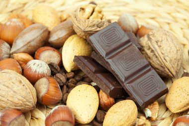 Bar of chocolate and nuts on a wicker mat