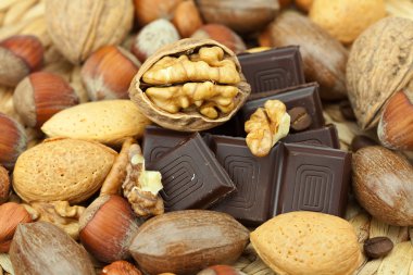 Bar of chocolate and nuts on a wicker mat