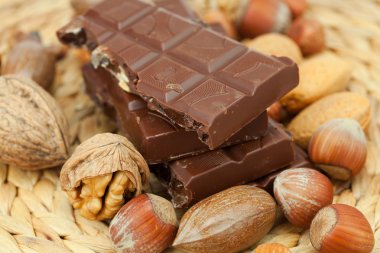 Bar of chocolate and nuts on a wicker mat