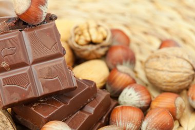 Bar of chocolate and nuts on a wicker mat