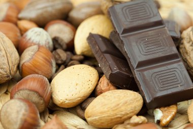 Bar of chocolate and nuts on a wicker mat