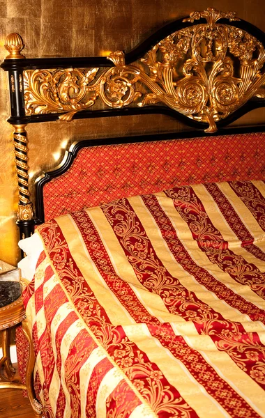 Cama en la habitación dorada del hotel — Foto de Stock