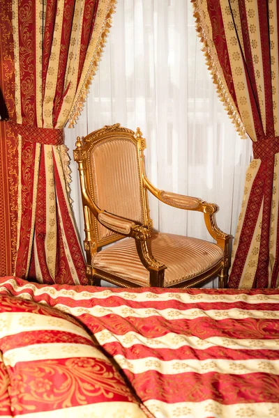Кровать и стул в золотой комнате отеля — стоковое фото