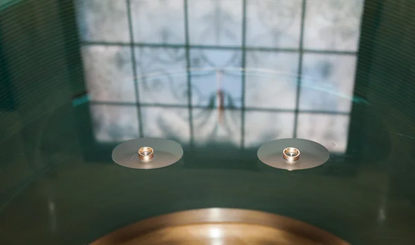 美しいステンド グラス、ガラス テーブルの上の結婚指輪 — ストック写真