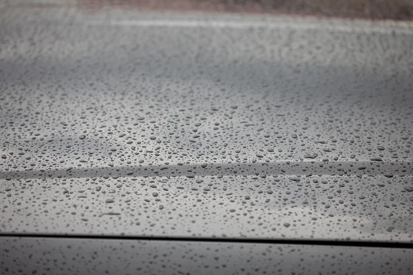 Vattendroppar på motorhuven på en bil — Stockfoto