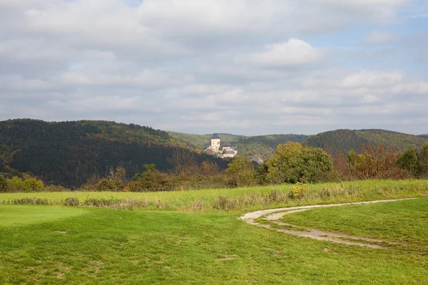 Поле на фоне средневекового замка и холмов — стоковое фото