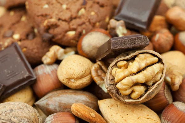 Kaurakeksejä, suklaata ja pähkinöitä pajumatossa — kuvapankkivalokuva