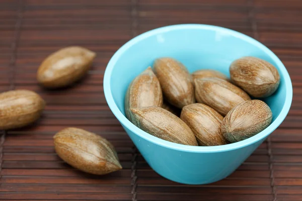 Pecans in a bowl on a bamboo mat — Stock Photo, Image