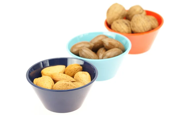 Nuts in bowls isolated on white — Stok fotoğraf